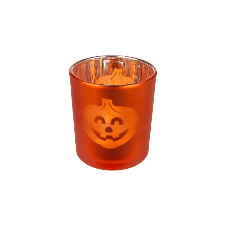 Bougie orange en verre avec un visage de citrouille souriant gravé.