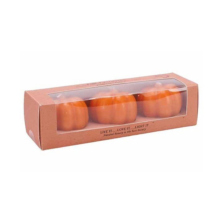 Trois bougies en forme de citrouille dans un emballage en carton transparent.