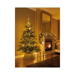Un sapin illuminé près d'une cheminée, ambiance chaleureuse et festive.