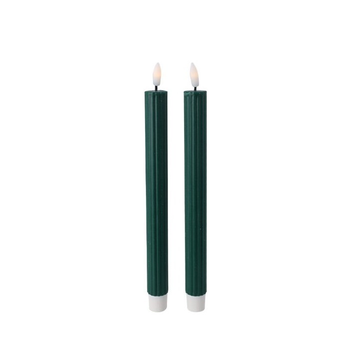Deux bougies vertes, élancées, avec des flammes délicates et une base blanche.