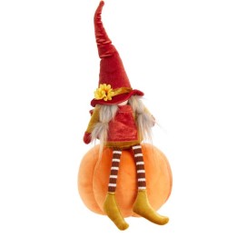 Poupée aux cheveux longs, chapeau rouge, assise sur une citrouille orange, style automnal.