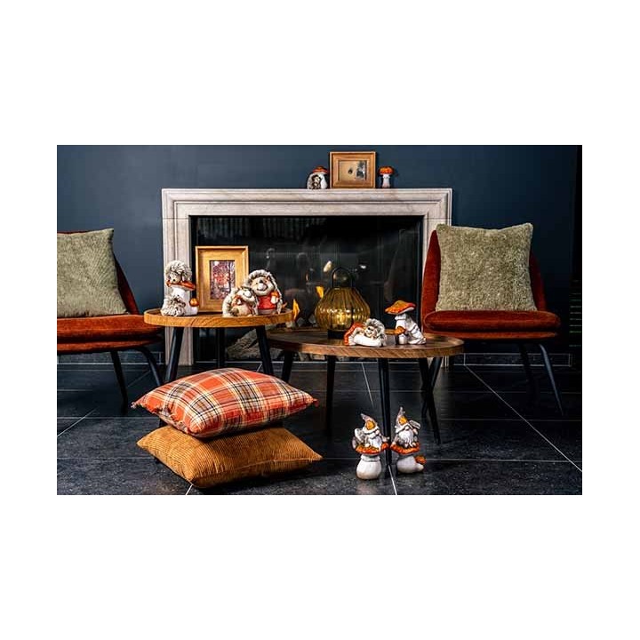 Intérieur chaleureux avec fauteuils, tables en bois, coussins colorés et décorations vintage.