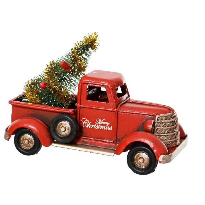 Camion rouge vintage avec un sapin décoré pour Noël à l'arrière.