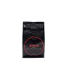 Sachet noir de café avec étiquette rouge, mentionnant "Kenya" et notes de chocolat. Sachet noir de café avec étiquette rouge, mentionnant "Kenya" et notes de chocolat.