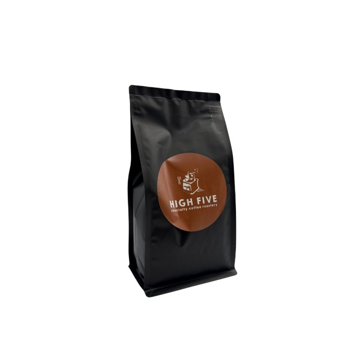 Sac noir élégant avec un logo rond marron, pour du café de qualité supérieure.