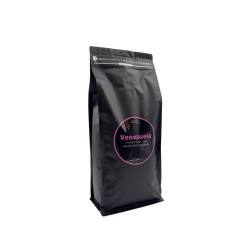 Sac noir de café, étiquette rose avec inscription "Venezuela", design minimaliste.