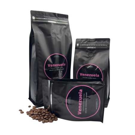 Trois sachets noirs de café avec étiquettes roses, entourés de grains de café. Trois sachets noirs de café avec étiquettes roses, entourés de grains de café.