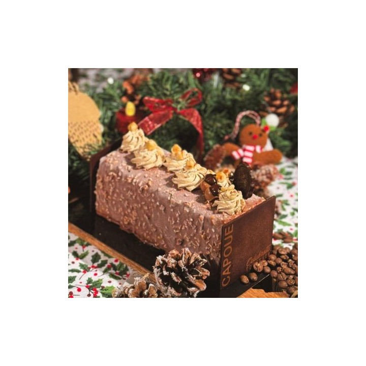 Bûche festive chocolatée, décorée de crème et de douceurs, sur fond de verdure et de décora...