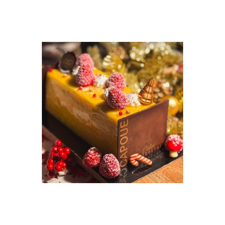 Gâteau rectangulaire aux fruits, décoré de framboises et de bonbons festifs.