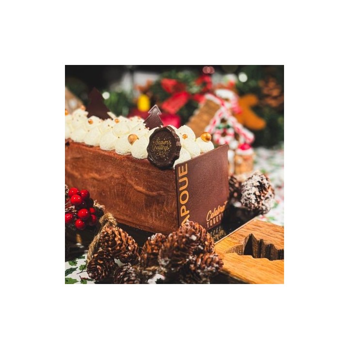 Gâteau festif en chocolat, décoré de crème, chocolat et éléments naturels, ambiance chaleur...