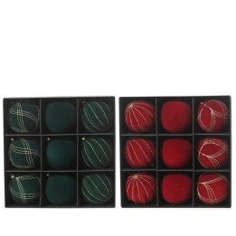 Ornements de Noël verts et rouges, élégamment disposés dans une boîte en noir.