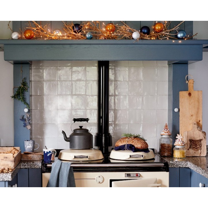 Cuisine chaleureuse avec un four vintage, décorée de guirlandes et d'ornements colorés.