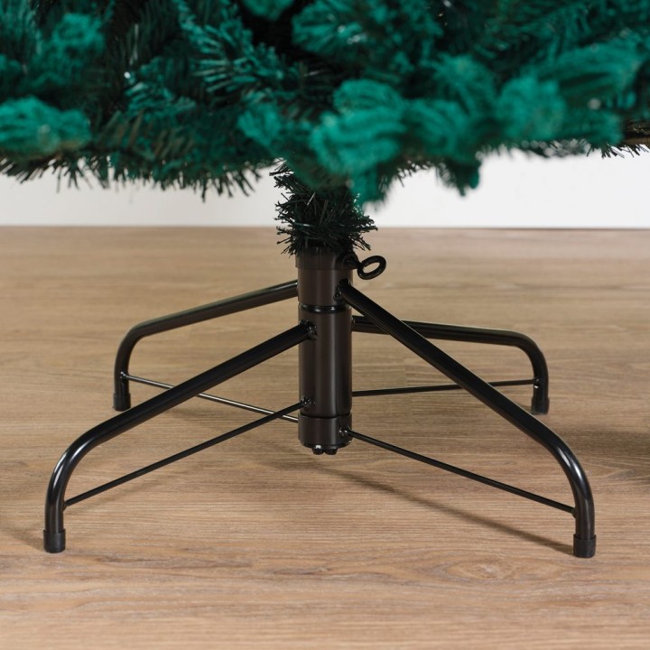 Base noire et métal d'un sapin artificiel sur un sol en bois clair. Feuillage vert dense.