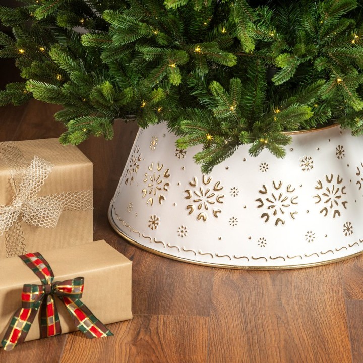 Sapin décoré avec un support blanc élégant, entouré de cadeaux festifs marron et rouge.