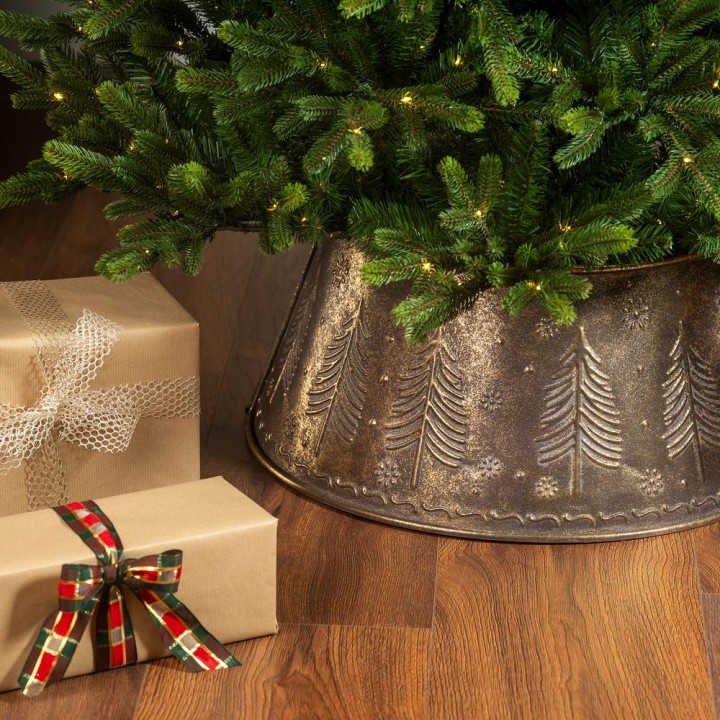 Sapin décoré, base métallique ornée, cadeaux emballés en kraft et ruban coloré.