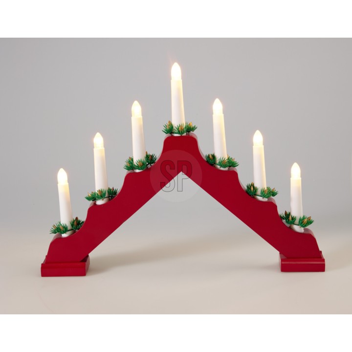 Lustre en bois rouge avec sept bougies blanches et décorations verdoyantes.