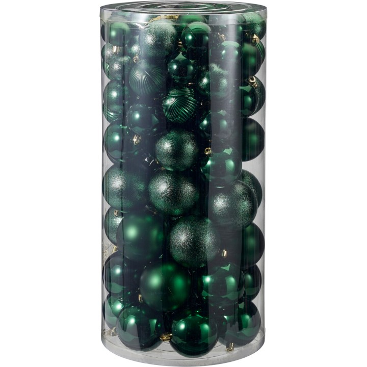 Ornements de Noël verts variés, brillants et mats, présentés dans un cylindre transparent.