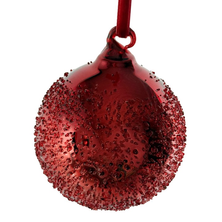 Ornement en verre rouge brillant, décoré de petites bulles et suspendu par un ruban.