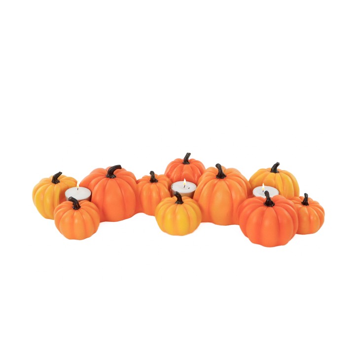 Groupe de citrouilles en céramique orange avec bougies blanches, ambiance automnale.